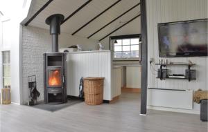 スナーヴィグにあるHoliday Home Lodbergsvej Ringkøbing Xiiの暖炉とテレビのあるリビングルーム
