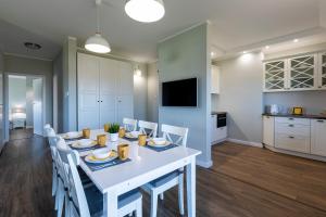a dining room with a white table and chairs at Amare Apartments A2 in Mosty