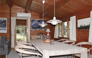 a dining room with a large wooden table and chairs at 3 Bedroom Beautiful Home In lbk in Ålbæk