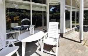 a white table and chairs on a patio at Holiday Home Bæverstien Denm Iv in Marielyst