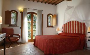 a bedroom with a red bed and a chair at Casale Refoli in Casole dʼElsa