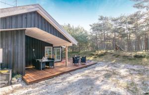 eine Holzterrasse mit einem Schreibtisch auf dem Dach eines Hauses in der Unterkunft Four-Bedroom Holiday Home In Nexo in Vester Sømarken + 12 Fotos