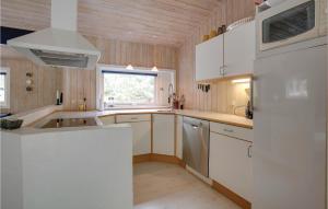 eine Küche mit weißen Schränken und einem Fenster in der Unterkunft Four-Bedroom Holiday Home In Nexo in Vester Sømarken