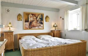 Un dormitorio con una cama grande con un cuadro en la pared. en Holiday Home Fyrmarken Iv, en Nørre Lyngvig 9 fotos más