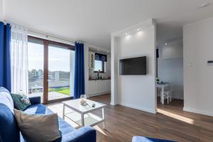 a living room with a blue couch and a table at Amare Apartments B1 in Mosty