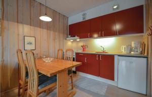 a kitchen with a wooden table with chairs and a counter at Lejl 64 in Rømø Kirkeby