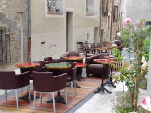 una fila de mesas y sillas en un patio en Demeure d'hôtes Le Rocher, en Valbonne