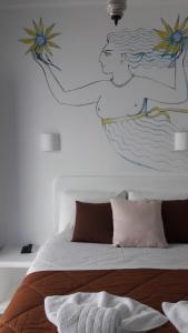 a bedroom with a bed with a painting on the wall at Heliotropio Studios & Apartments in Pollonia