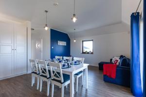 a dining room with a white table and chairs at Amare Apartments B2 in Mosty