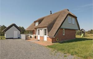 a house with a thatched roof and a garage at Nice Home In Blvand With Wifi in Blåvand