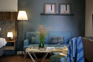 a living room with a blue couch and a table at Kaia Residence Danang Quiet Garden in Danang