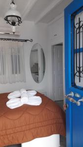 - une chambre avec un lit et des serviettes dans l'établissement Heliotropio Studios & Apartments, à Pollonia