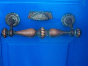 una porta blu con un manico su una parete blu di Heliotropio Studios & Apartments a Pollonia