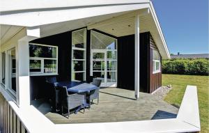 a screened porch with a table and chairs on a house at Holiday Home Toften Hadsund V in Nørre Hurup +13 photos