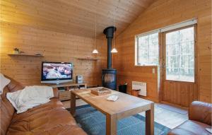 HelberskovにあるStunning Home In Hadsund With 3 Bedroomsのリビングルーム(ソファ、テーブル、テレビ付)