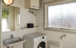 a bathroom with a washing machine and a sink at Cozy Home In Rm With Kitchen in Bolilmark