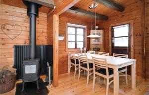 a dining room with a stove and a table and chairs at Nice Home In Pandrup With 3 Bedrooms, Sauna And Wifi in Blokhus