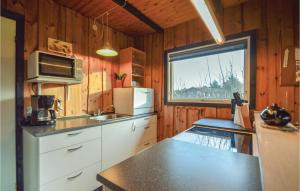 een keuken met witte kasten, een magnetron en een raam bij Cozy Home In Rm With Kitchen in Bolilmark