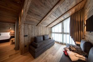 a living room with a couch and a bed at Rifugio Salei in Canazei