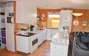 een kleine keuken met witte kasten en een wastafel bij 3 Bedroom Gorgeous Home In Vggerlse in Bøtø By