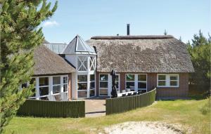 una casa con techo de paja y patio en Beautiful Home In Rm With Wifi, en Rømø Kirkeby