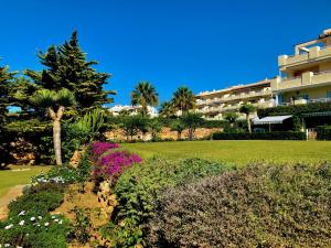 a garden with flowers in front of a building at lovely sea views apartment on La Costa del Sol in Mijas Costa