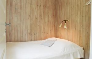 a bed in a room with a wooden wall at Lovely Home In Rm With Wifi in Bolilmark