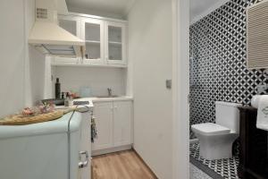 a small white kitchen with a sink and a toilet at CASA VERDE in Corfu Town +90 photos