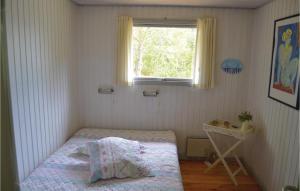 a small bedroom with a bed and a window at Holiday Home Uranusvej in Ålbæk +3 photos