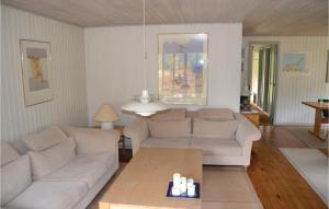 a living room with two couches and a coffee table at Holiday Home Uranusvej in Ålbæk