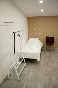 een ziekenhuiskamer met een bed en een stoel bij OXCafe Hostel in Kose-Uuemõisa