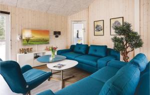 un soggiorno con divani blu e un tavolo di Awesome Home In Frederiksvrk With Kitchen a Melby