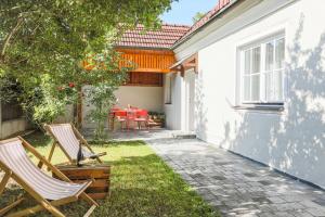 ein Paar Stühle im Hinterhof eines Hauses in der Unterkunft MALAT Ferienhaus in Furth