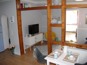 ein Wohnzimmer mit einem Tisch und einem TV in der Unterkunft moij Stuuv in Greetsiel
