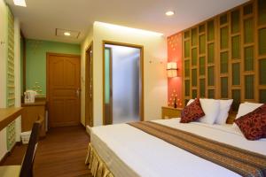 a hotel room with a bed and a bathroom at Golden House BTS Chidlom Bangkok in Bangkok +12 photos