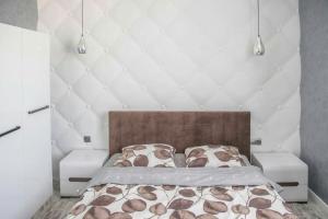 um quarto com uma cama com uma parede branca em Апартаменти в центрі Львова em Lviv