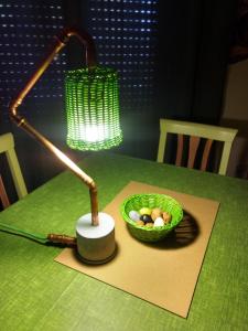 una lámpara sentada en una mesa con una cesta de verduras en Appartamento Salvatore, en Campagnano di Roma