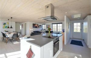 a kitchen and living room with a counter and a table at Five-Bedroom Holiday Home In Ulfborg in Ulfborg
