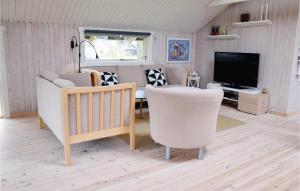 sala de estar con sillas blancas y TV en 3 Bedroom Awesome Home In Otterup, en Otterup