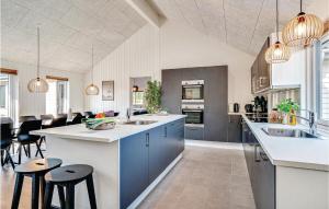 a large kitchen with blue cabinets and a dining room at Lovely Home In Nrre Nebel With Wifi in Nørre Nebel