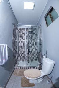 La salle de bains est pourvue d'une douche, de toilettes et d'une baignoire. dans l'établissement Ndussole House, à Talatona
