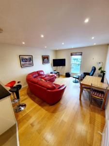uma sala de estar com um sofá vermelho e uma mesa em Beach View Ballycastle Escape em Ballycastle