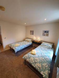 um quarto com duas camas e duas mesas em Beach View Ballycastle Escape em Ballycastle