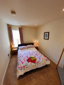 um quarto com uma cama com um edredão colorido em Beach View Ballycastle Escape em Ballycastle