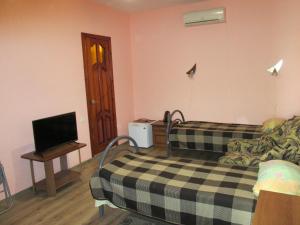 a room with two beds and a flat screen tv at Italian Courtyard in Feodosiya