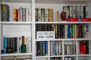 a shelf of books with a sign that reads like the life you love at Design Apartment Harz-Relax in Harzgerode