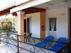a balcony of a house with blue chairs at Kostas Apartments & studios in Agios Georgios Pagon