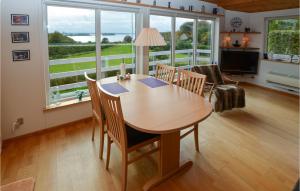 comedor con mesa y sillas y ventana grande en Cozy Home In Krus With House Sea View, en Kruså