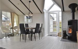 a dining room with a table and chairs and a fireplace at Stunning Home In Ringkbing With Kitchen in Søndervig