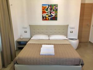 een slaapkamer met een bed en een schilderij aan de muur bij Mon Rêve in Camposano